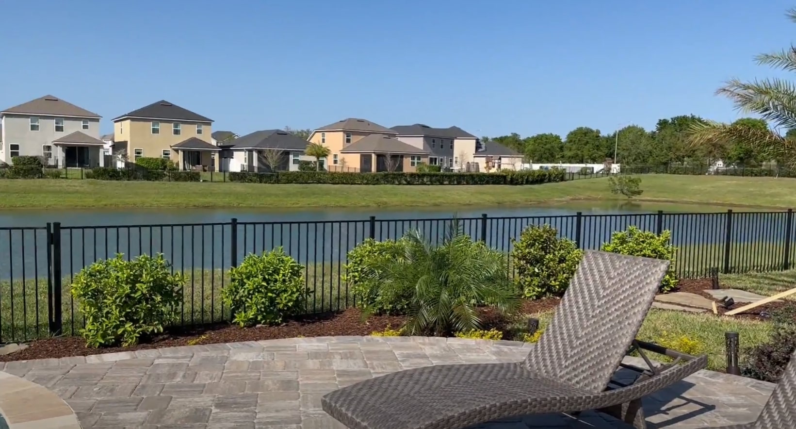 Beautiful backyard patio with outdoor furniture overlooking water feature and landscaped yard