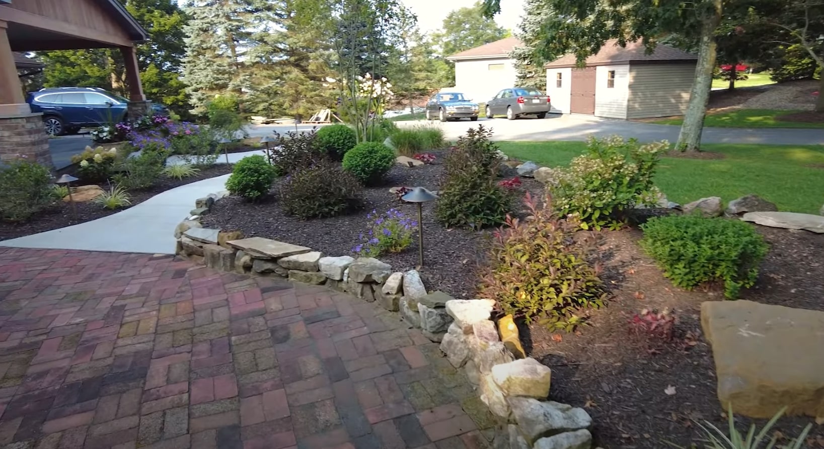 Professional landscape with mature trees and well-maintained shrubs creating natural privacy screening