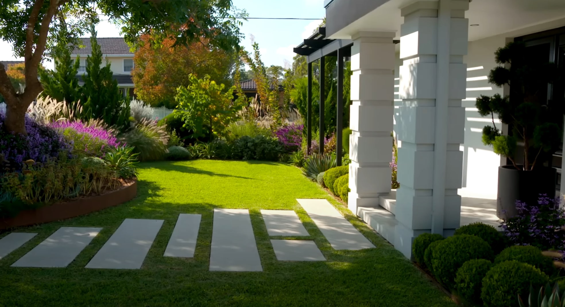 Modern landscape design with perfect lawn and decorative concrete walkway